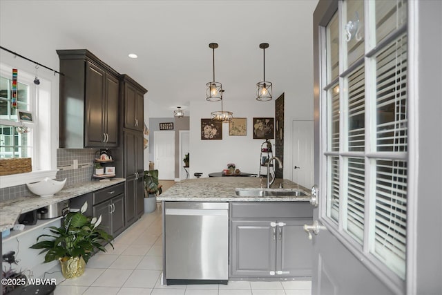 kitchen featuring dark brown cabinets, dishwasher, backsplash, light tile patterned floors, and sink