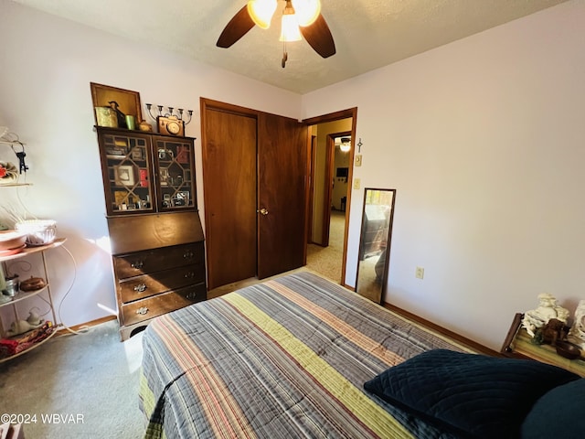 carpeted bedroom featuring a textured ceiling, a closet, and ceiling fan