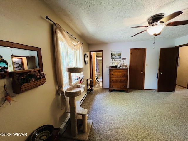 living area featuring carpet, ceiling fan, and a textured ceiling