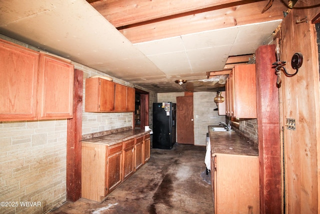 486 Mcintyre Way, Cogan Station, PA 17728 - kitchen featuring black fridge with ice dispenser, a sink, concrete floors, and brown cabinetry