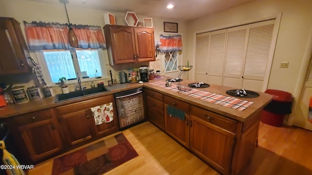 kitchen with sink, light hardwood / wood-style floors, kitchen peninsula, and dishwasher