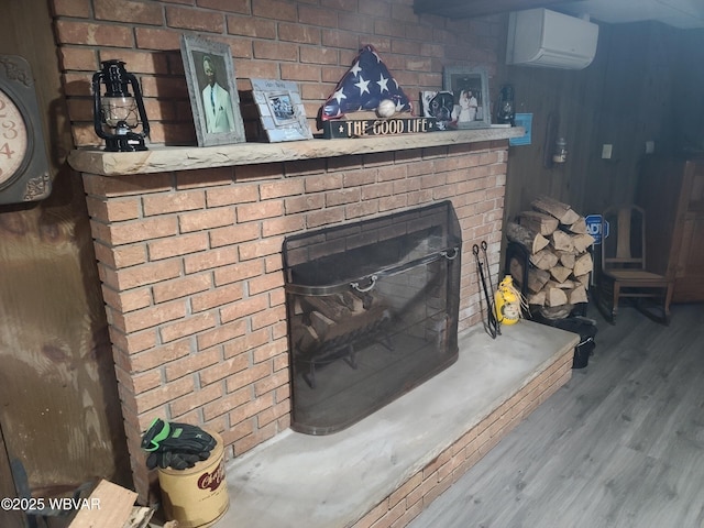 details with hardwood / wood-style flooring, a brick fireplace, and a wall mounted air conditioner