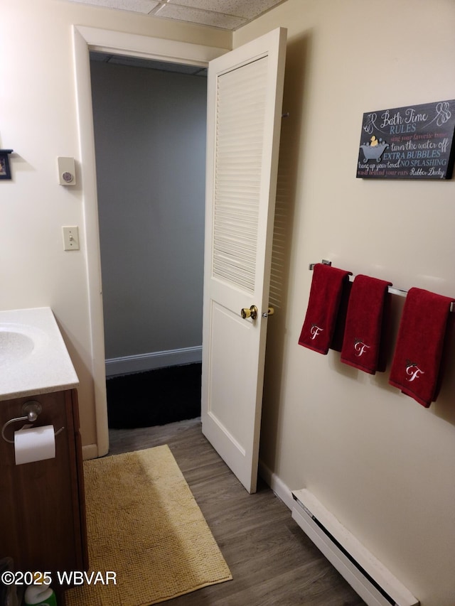 bathroom with baseboard heating, vanity, and hardwood / wood-style flooring