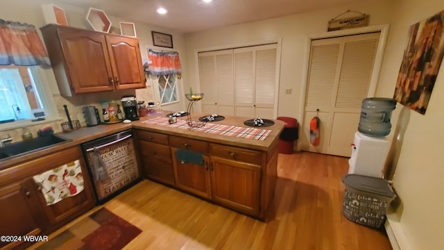 kitchen with sink, light hardwood / wood-style flooring, tile countertops, stainless steel dishwasher, and kitchen peninsula