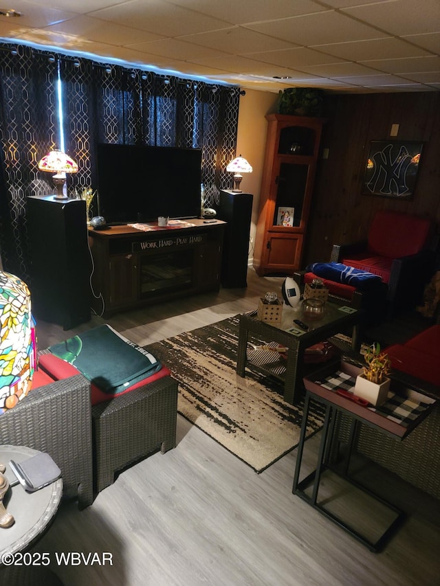 living room with hardwood / wood-style floors and a drop ceiling