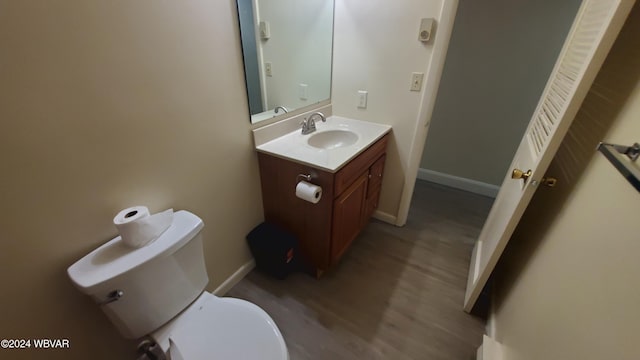 bathroom with hardwood / wood-style flooring, vanity, and toilet