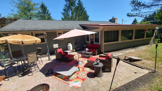 back of property with an outdoor living space and a patio