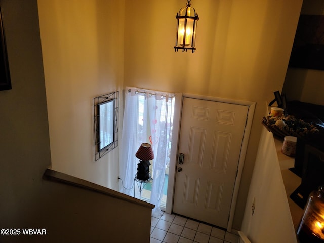 entrance foyer with a towering ceiling and light tile patterned floors