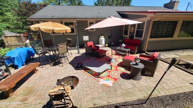 view of patio featuring an outdoor living space with a fire pit