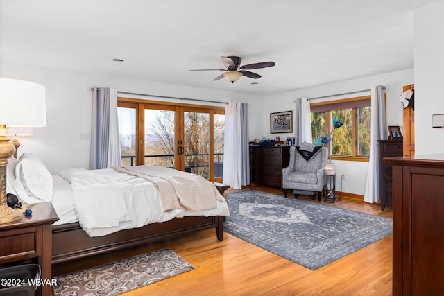 bedroom featuring hardwood / wood-style floors, ceiling fan, access to outside, and multiple windows