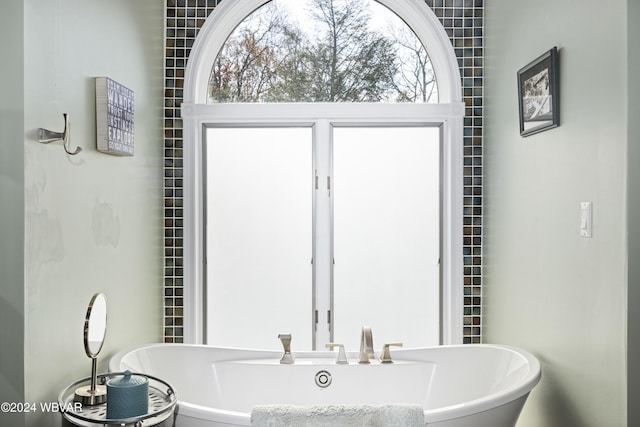 bathroom featuring a tub to relax in and plenty of natural light