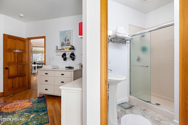 bathroom featuring sink, an enclosed shower, and hardwood / wood-style flooring