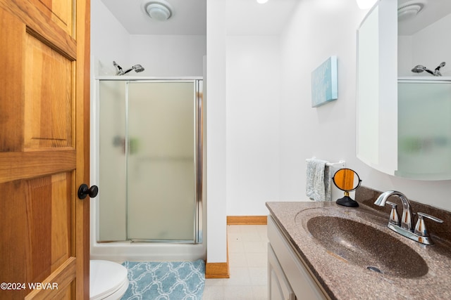 bathroom with a shower with door, vanity, and toilet