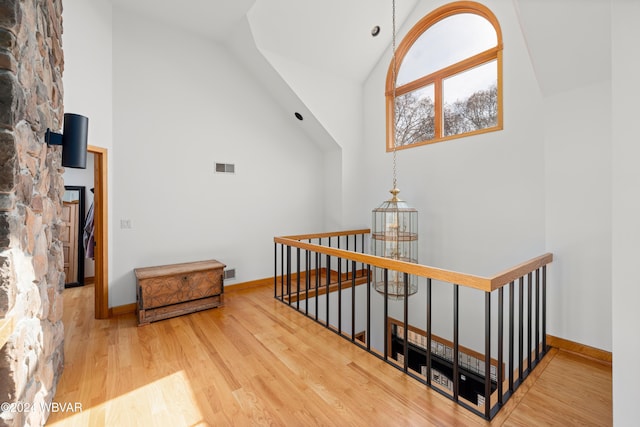 stairway with wood-type flooring and high vaulted ceiling