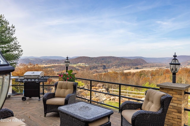 deck with a grill and a mountain view