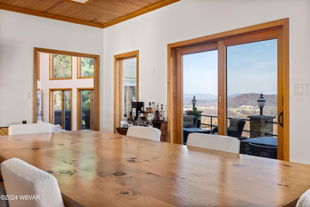 dining area featuring a mountain view, wood ceiling, and crown molding