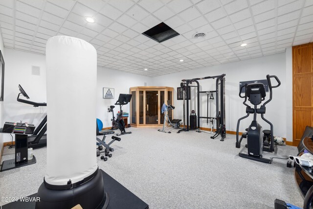 workout room featuring carpet flooring and a paneled ceiling