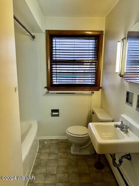 bathroom featuring a bathing tub, toilet, and sink