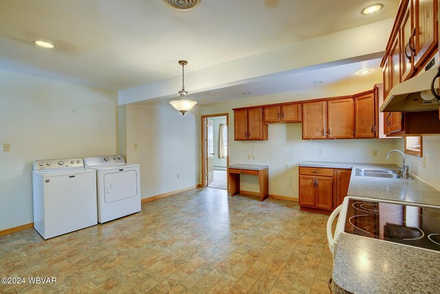 65 Spring St, Lock Haven, PA 17745 - kitchen with washer and dryer, under cabinet range hood, decorative light fixtures, brown cabinetry, and light countertops