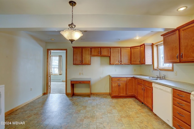 kitchen featuring brown cabinets, baseboards, white dishwasher, and a sink