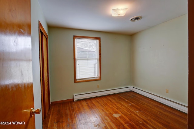 65 Spring St, Lock Haven, PA 17745 - unfurnished bedroom with baseboard heating, hardwood / wood-style flooring, a baseboard heating unit, and a closet