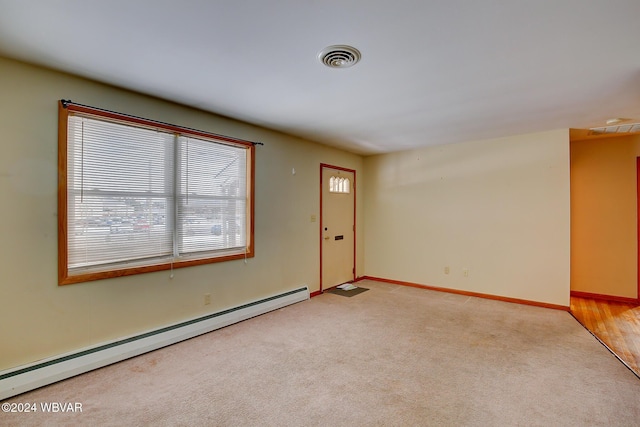 empty room featuring light carpet and a baseboard radiator