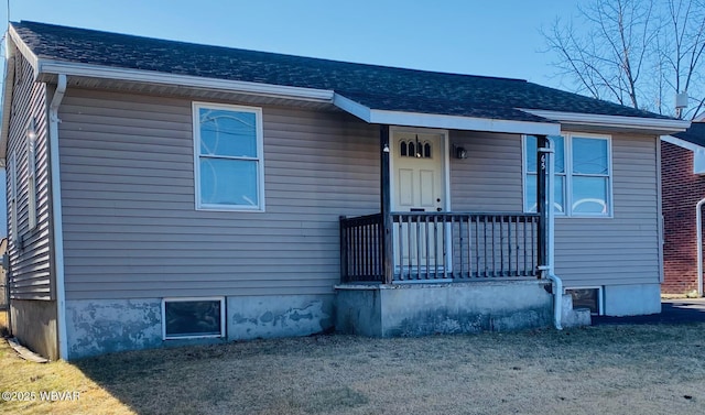 view of front of property with a porch and roof with shingles