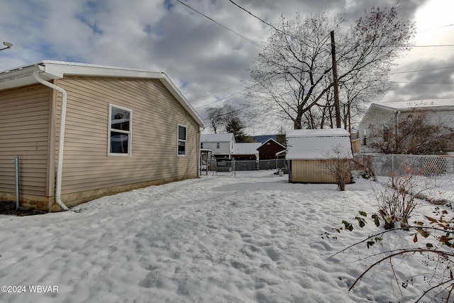 snowy yard with a storage unit