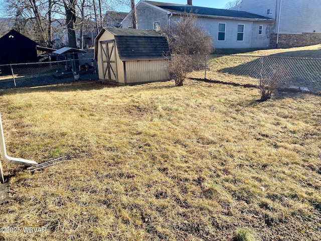 view of yard featuring a fenced backyard, a storage unit, and an outbuilding