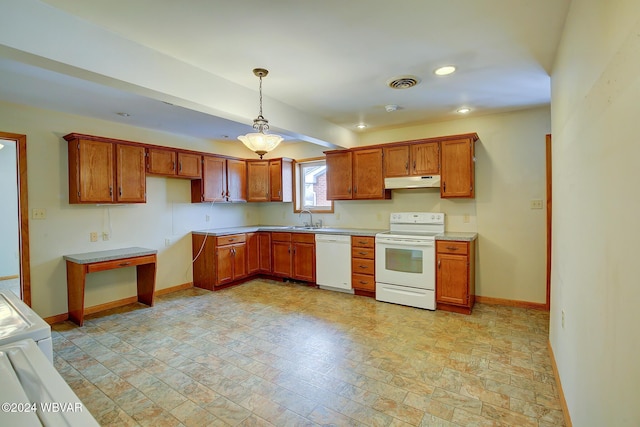 kitchen featuring white appliances, brown cabinets, under cabinet range hood, and baseboards