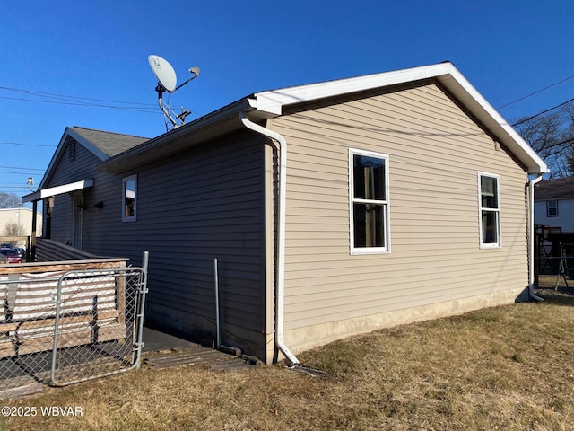 view of home's exterior featuring fence and a lawn