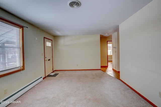 unfurnished room featuring a baseboard radiator, visible vents, baseboards, and light colored carpet