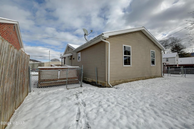 snow covered house with fence