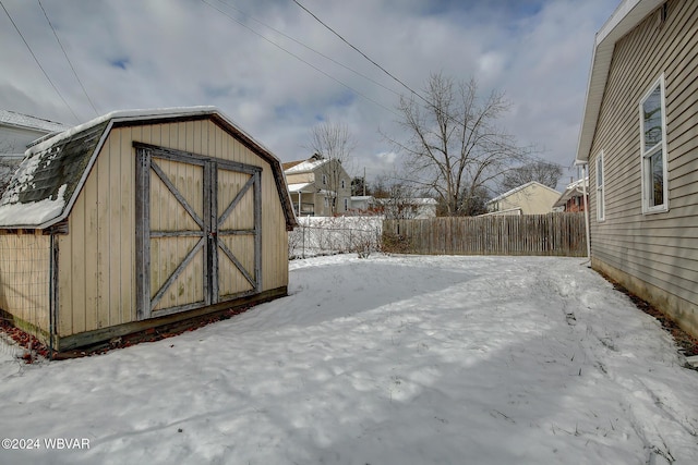 yard covered in snow featuring a shed