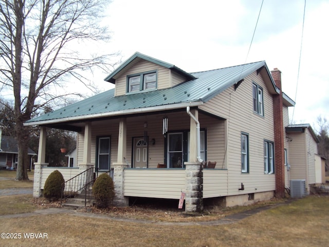 view of front facade featuring covered porch, central AC unit, and metal roof