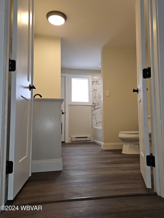 bathroom featuring toilet, wood-type flooring, and baseboard heating