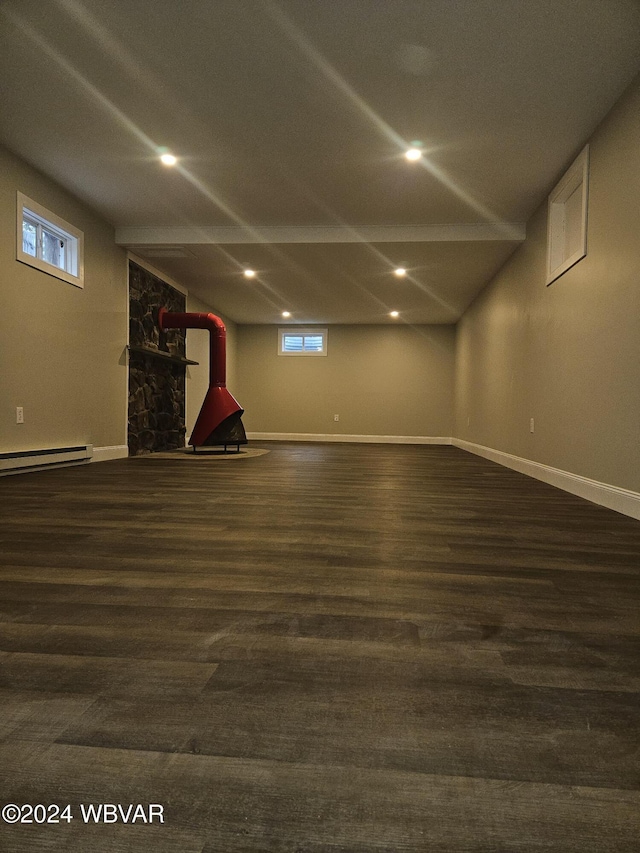 basement with a baseboard heating unit and dark wood-type flooring