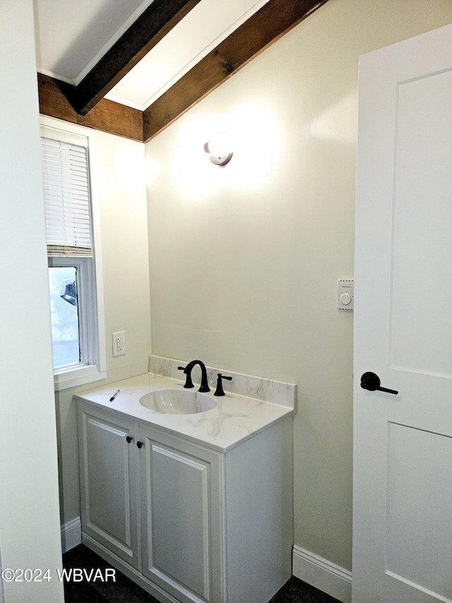 bathroom with beam ceiling and vanity