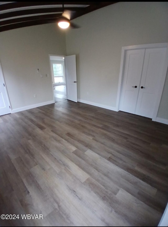 empty room with lofted ceiling with beams, ceiling fan, and wood-type flooring