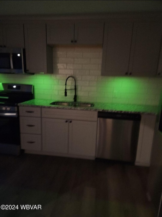 kitchen with backsplash, dark hardwood / wood-style flooring, sink, and appliances with stainless steel finishes