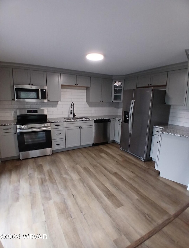 kitchen with gray cabinetry, sink, and appliances with stainless steel finishes