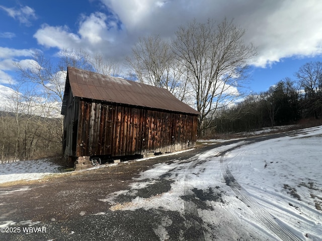 snow covered structure featuring an outbuilding