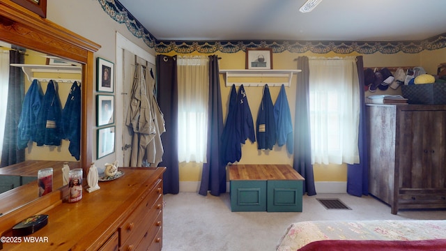 bedroom featuring light colored carpet, visible vents, and baseboards