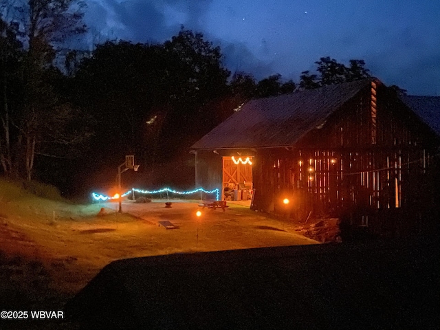 front of house at twilight featuring an outbuilding