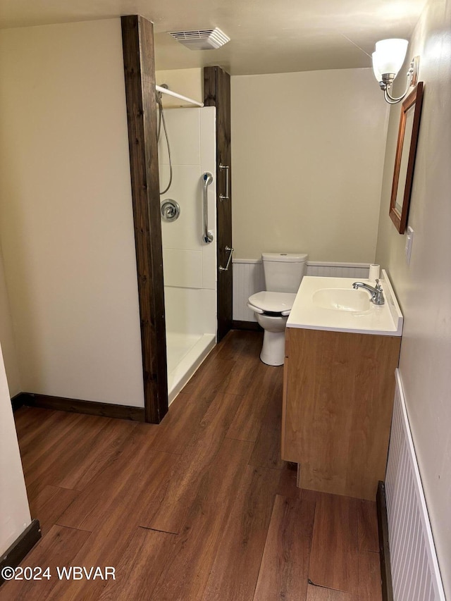 bathroom with a shower, wood-type flooring, vanity, and toilet