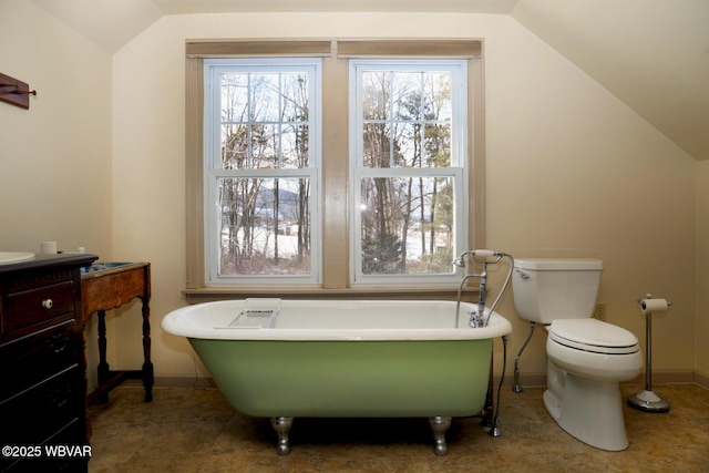 190 E Winter Rd, Loganton, PA 17747 - bathroom with lofted ceiling, a freestanding tub, baseboards, vanity, and toilet