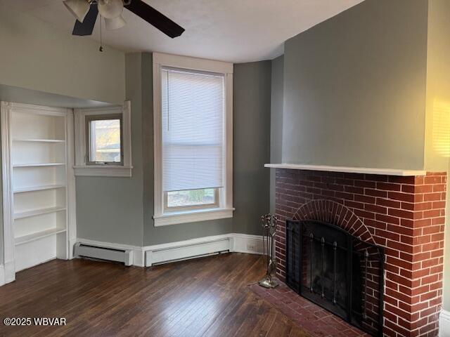 unfurnished living room featuring a fireplace, a baseboard heating unit, ceiling fan, and wood finished floors