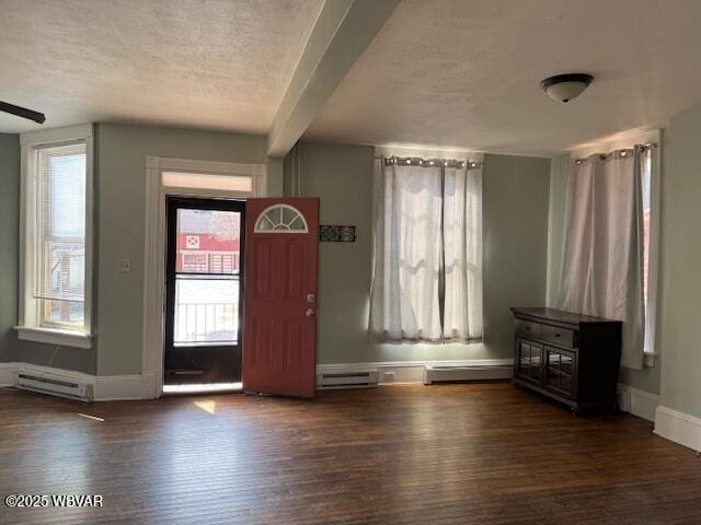 entryway with beam ceiling, wood finished floors, baseboards, and a textured ceiling