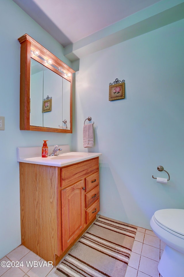 bathroom with tile patterned flooring, vanity, and toilet