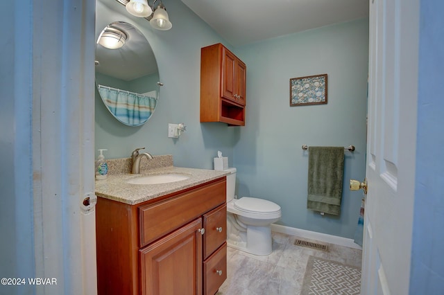 bathroom featuring tile patterned flooring, vanity, and toilet